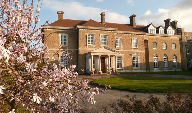 front of sand-coloured historic building with pillars at the doorway