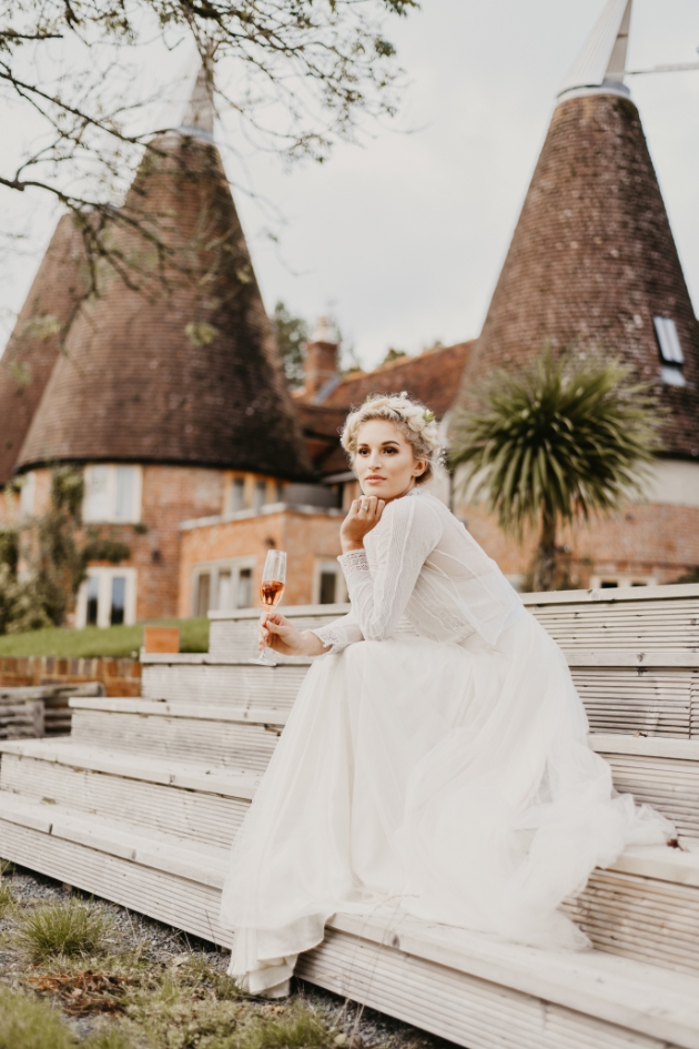 Bride sits on stairs at Oastbrook Estate Vineyard