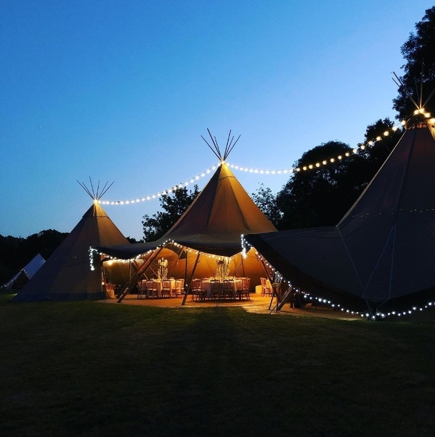 Great British Tipis lit at night for a wedding