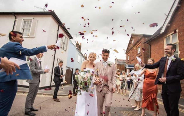 bride and groom walking down street confetti thrown at them