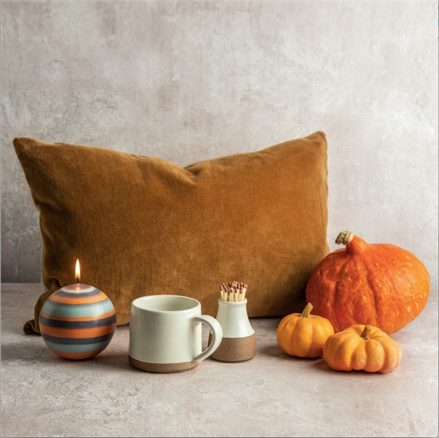 Contents of the Hygge box including a cushion, candle, mug and pumpkins