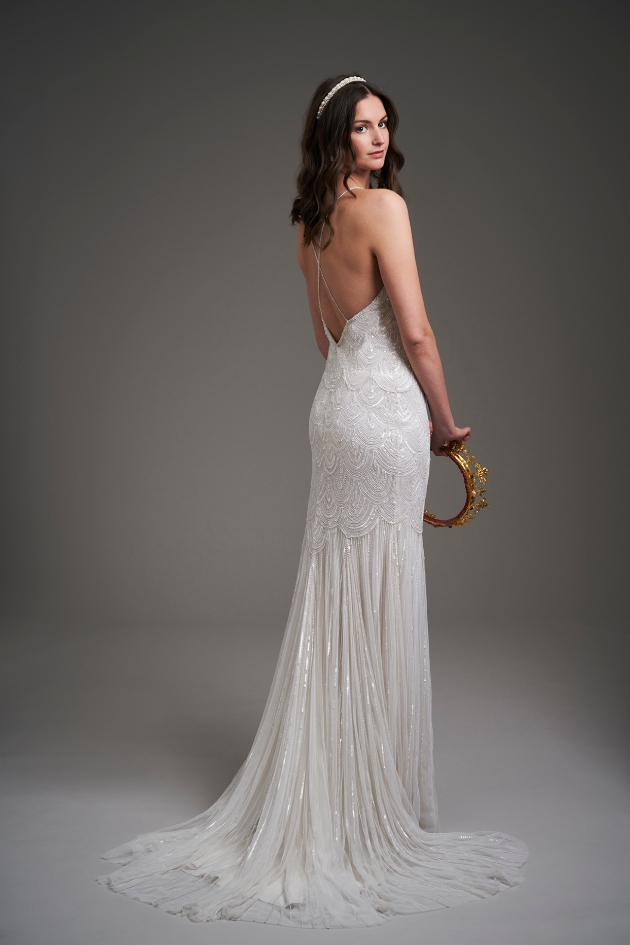 back shot of model wearing a wedding dress and holding a crown