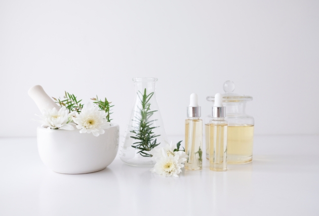 Pestle and mortar on table with perfume bottles 