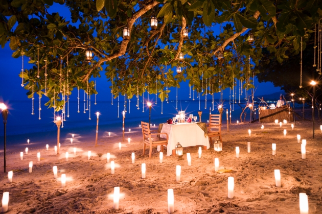 Thailand’s The Sarojin, dining table on the beach with candles in the sand