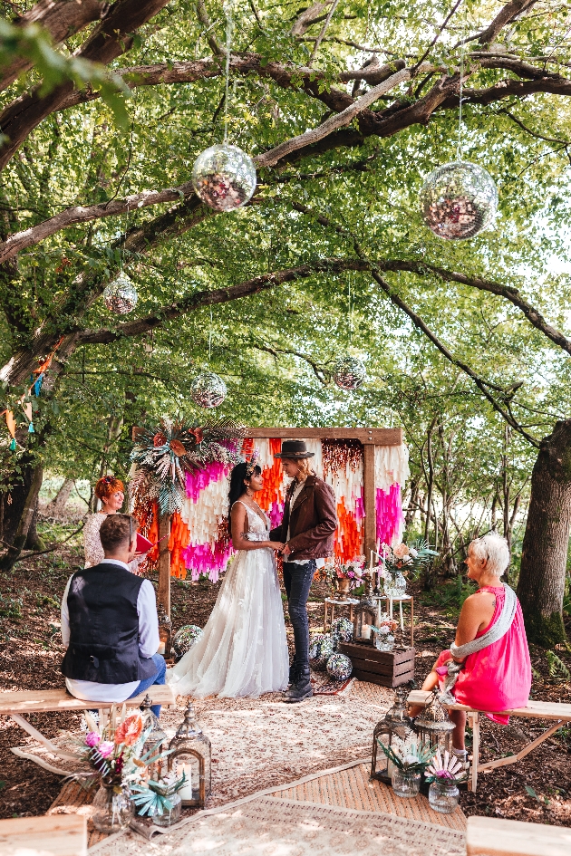 Festival wedding ceremony with mirrorballs hanging from trees