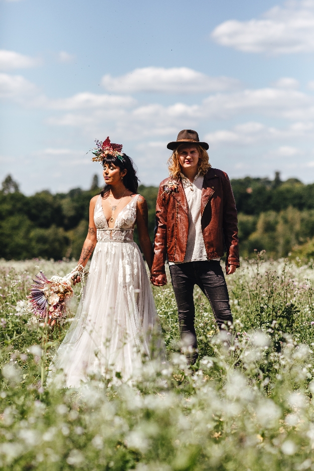 festival wedding couple standing in meadow full of white flowers
