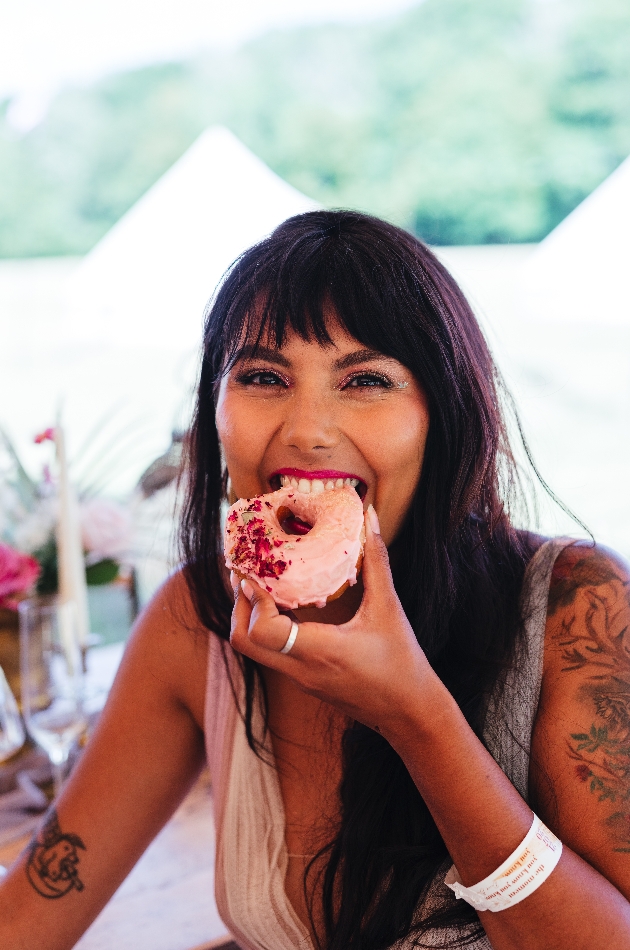 Bride enjoying a pink iced doughnut