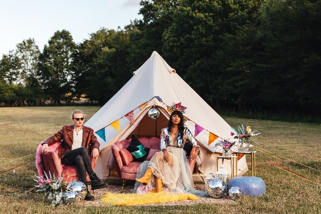 couple sitting in front of brightly decorated bell tent