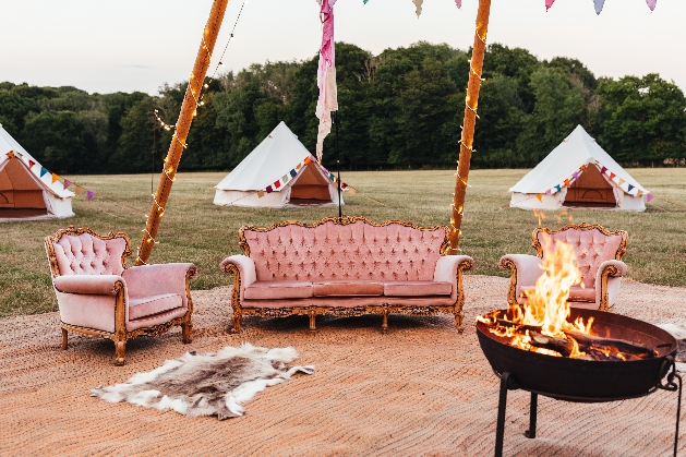 interior of open tipi scructure with sofas and firepit