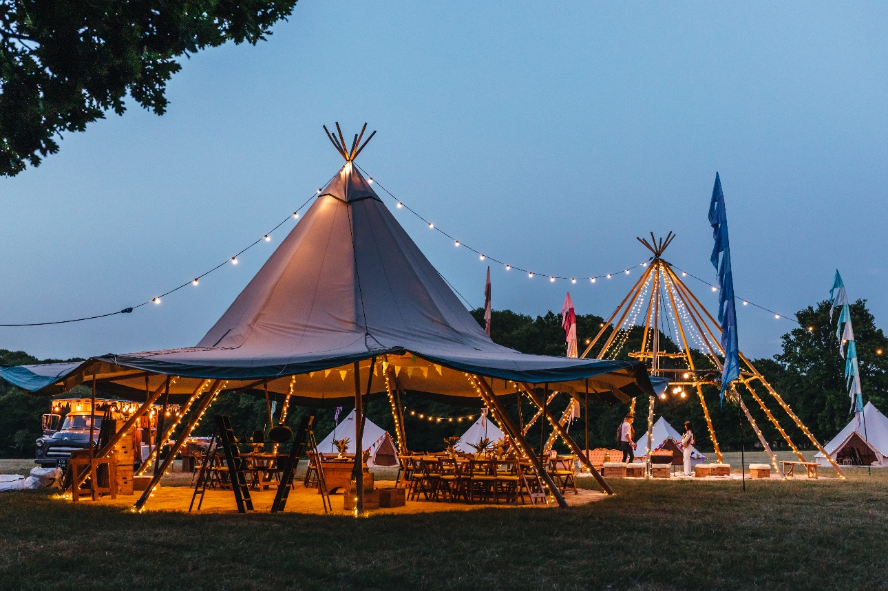 open sided tipi lit up at dusk