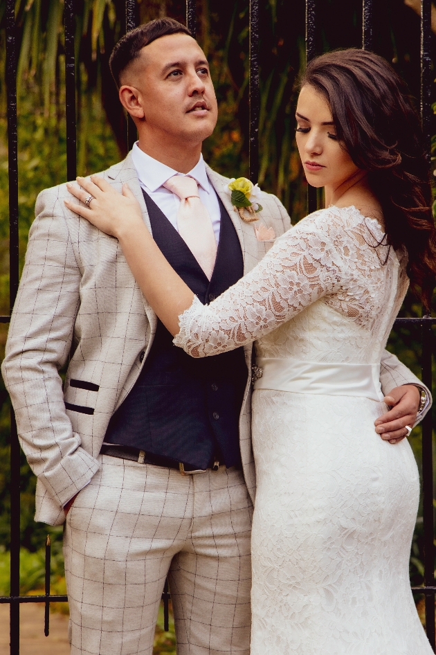 Bride and groom. Groom is dressed in a check suit, navy waistcoat with yellow buttonhole