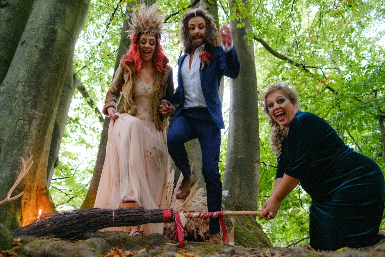 Bride and groom jumping over the boom as part of their handfasting ceremony