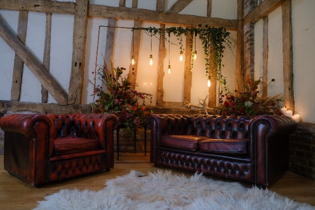 Intimate wedding barn set up with backdrop and brown leather sofas