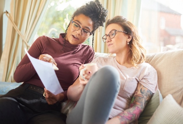 couple on sofa looking at document