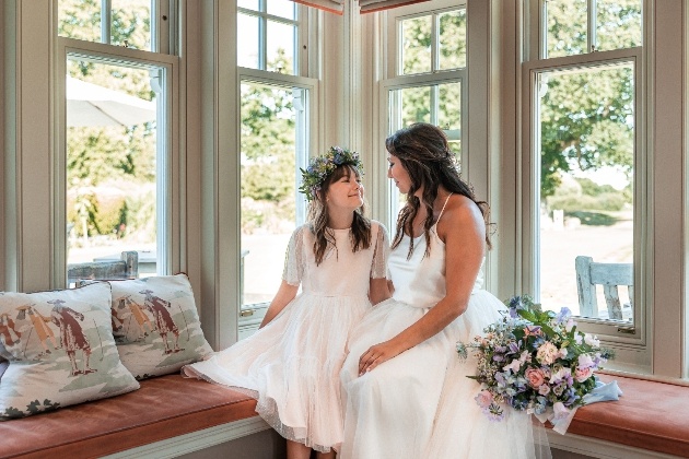 Bride and flowergirl on window seat