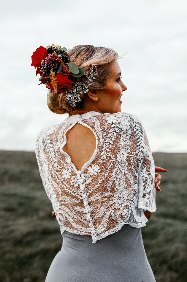 Bride wearing grey and white dress with red floral hair piece