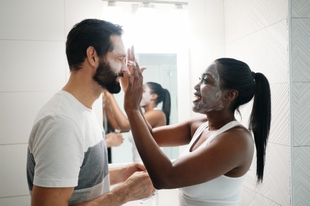 woman wearing a face mask and applying it to her partner