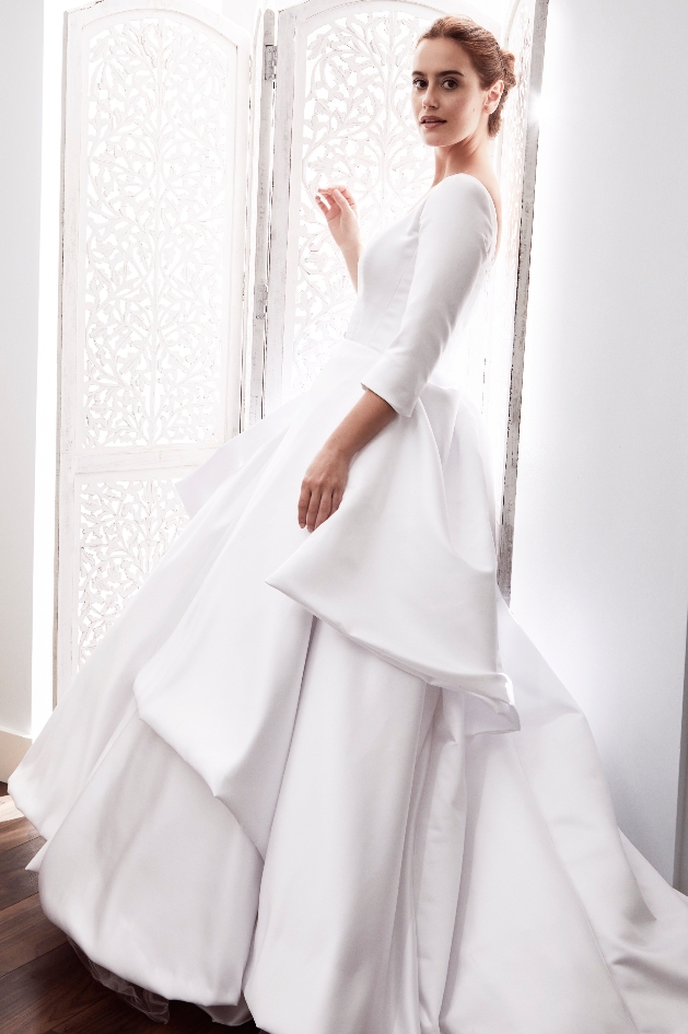 model wearing white ruffled dress with sleeves