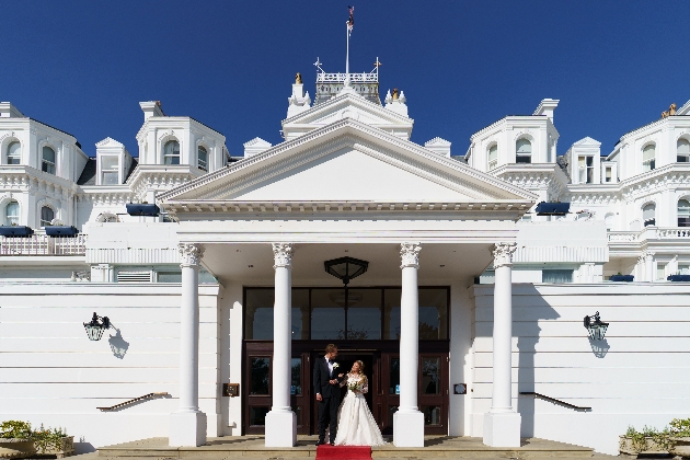 Exterior of The Grand Eastbourne with bride and groom standing on the steps
