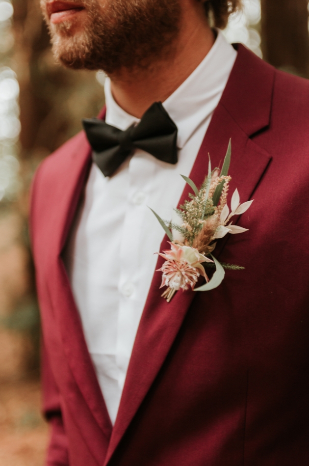 grooms buttonhole featuring pink pampas groom wears burgundy suit
