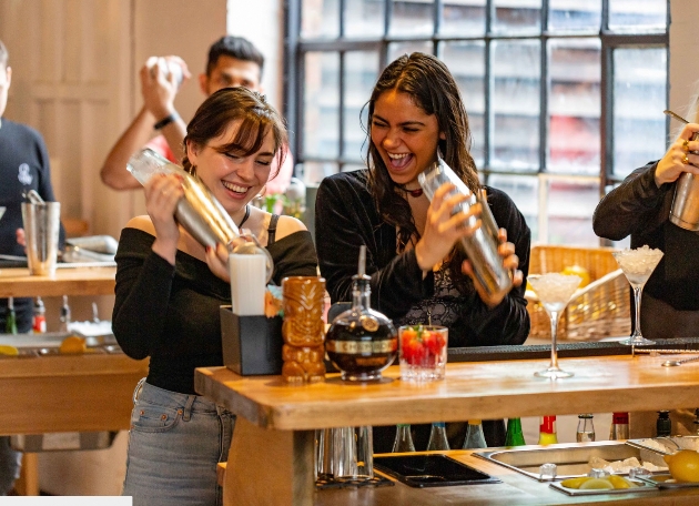 Two women on a hen do making cocktails