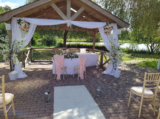 gazebo ceremony area decorated in a blush pink theme with drapes and flowers