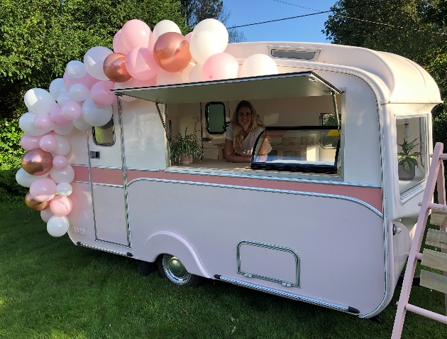 Caravens caravan decorated with balloons and staff member inside