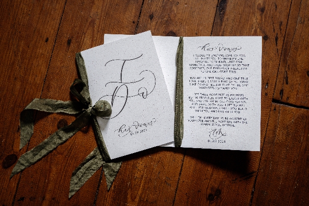 Hand calliagraphed vow booklet with green ribbon