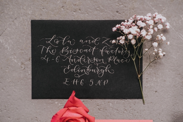 black envelope with white calligraphy wedding invitation