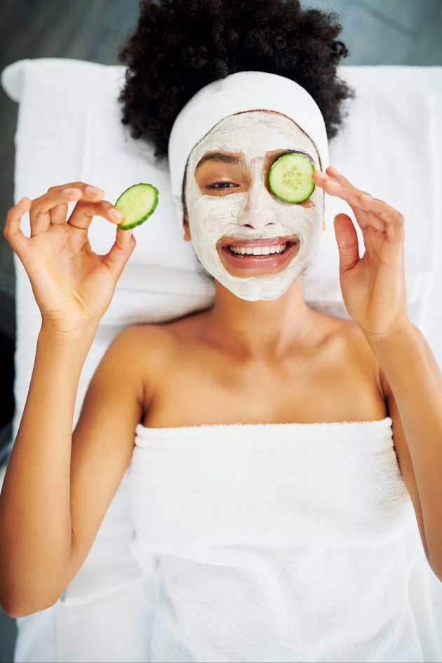 woman wearing beauty face mask and cucumbers on her eyes