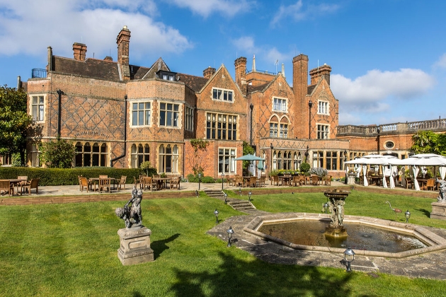 historic manor house with fountain and terrace with umbrellas