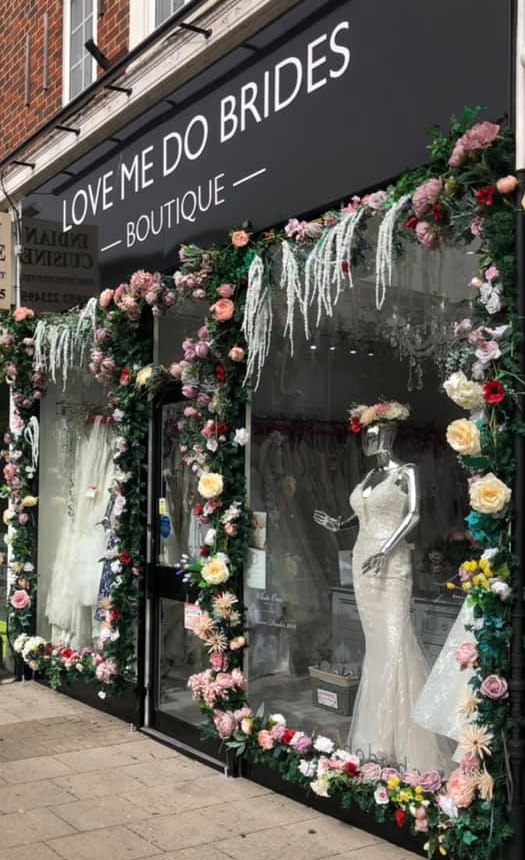front of bridal shop black facade covered in flowers