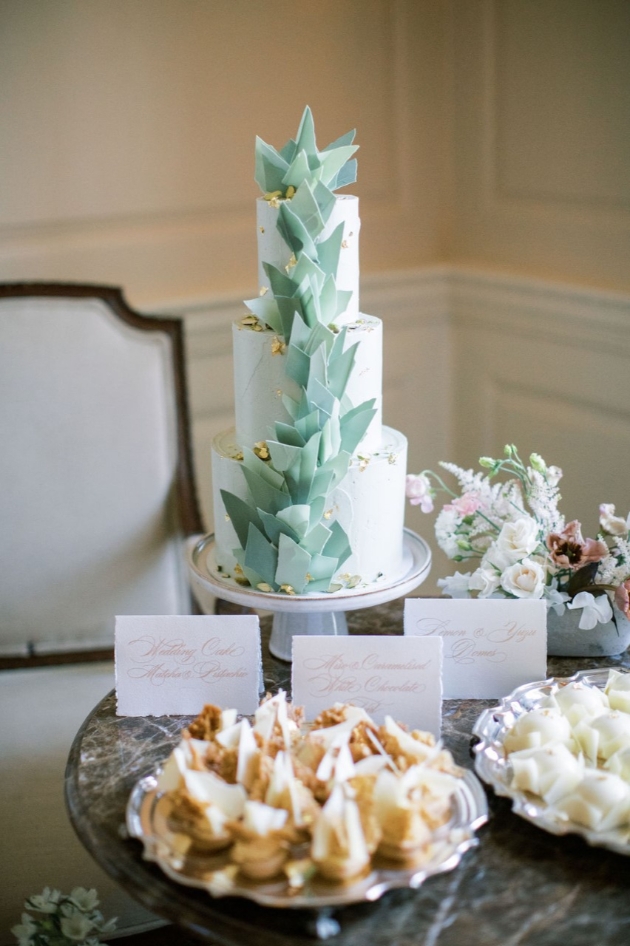 Three tier wedding cake with soft green 3D geometric design.