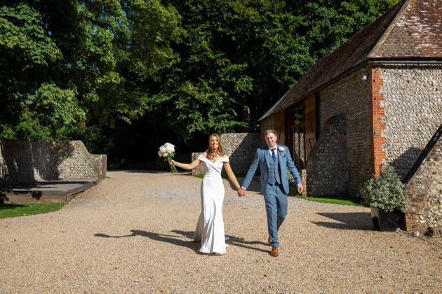 Couple walking hand in hand outside Cissbury Barns