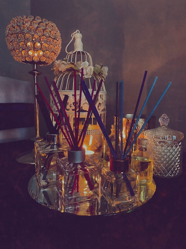 Diffusers placed on a table next to a candle