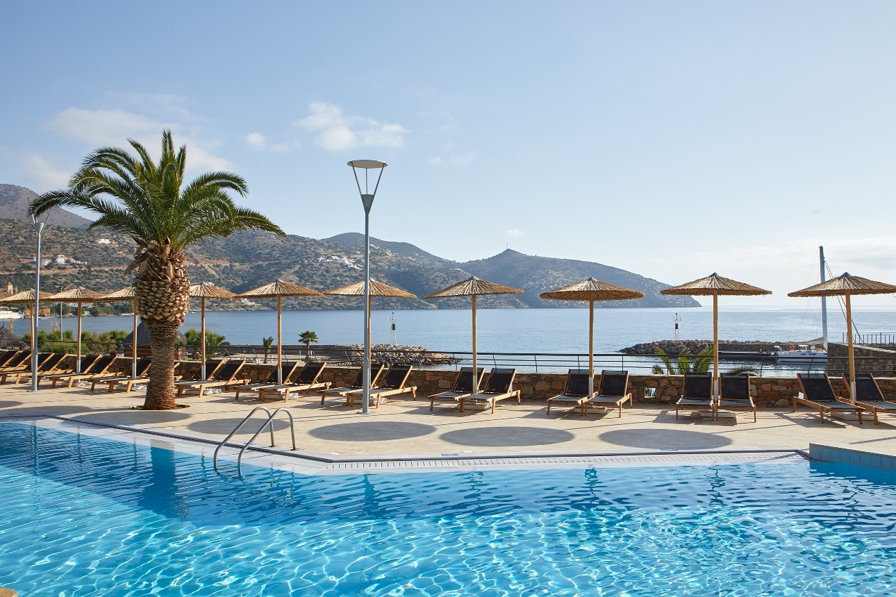 pool with sunlongers on terrace with see and mountain views