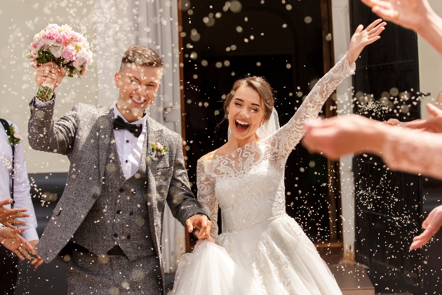 Bride and groom leaving ceremony through a shower of confetti
