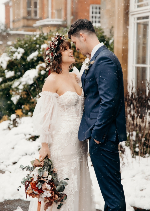 Bride and groom standing outside in the snow