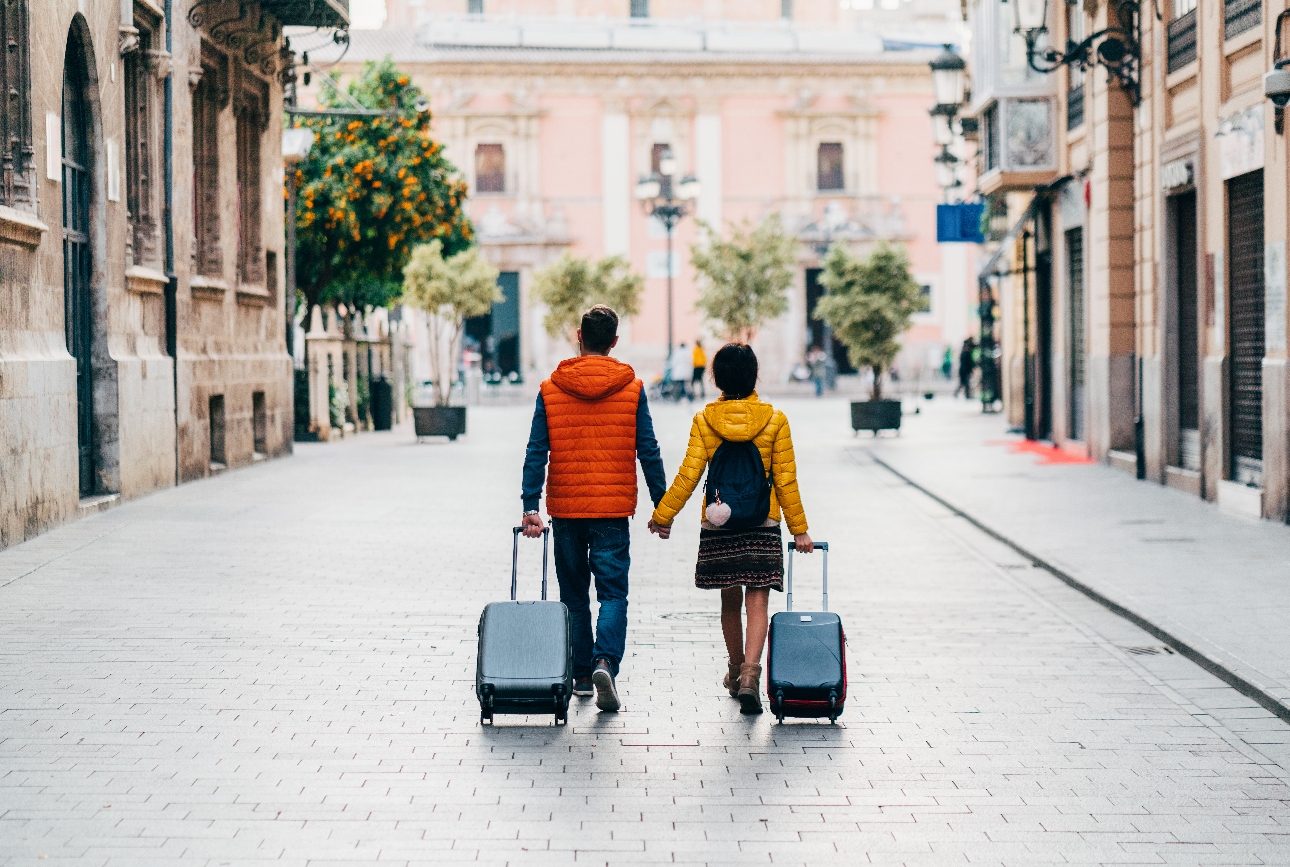 couple walking through foreign city with suitcases