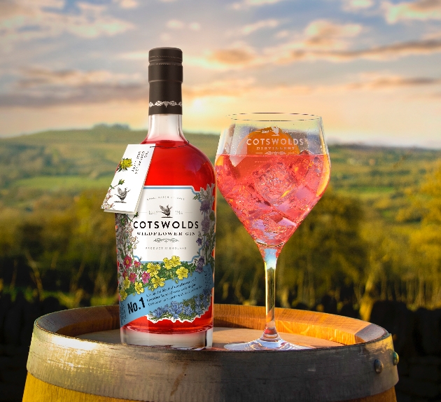 red gin on a barrel with glass next to it at sunset