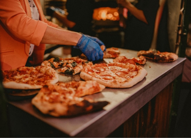 someone serving up wood fired pizzas