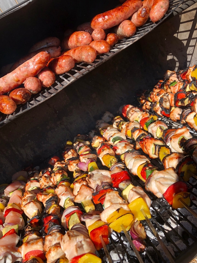 barbecue stacked with skewers and sausages