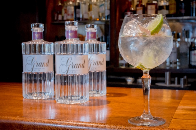 Three bottles of the new The Grand Gin with full glass