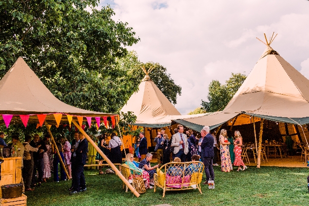a wedding taking place in a tipi guests mingling bright decor