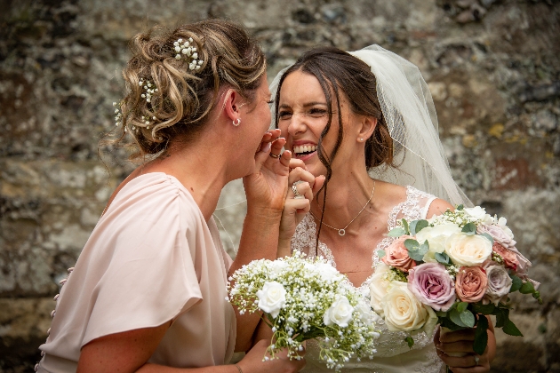 Bride and bridesmaid giggling together