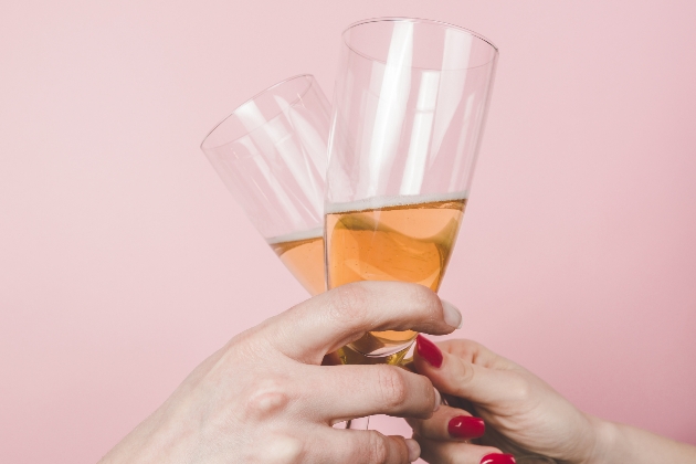 close up of champagne flutes holding pink bubbly