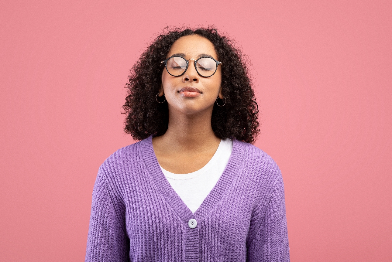 woman in purple jumper eyes shut