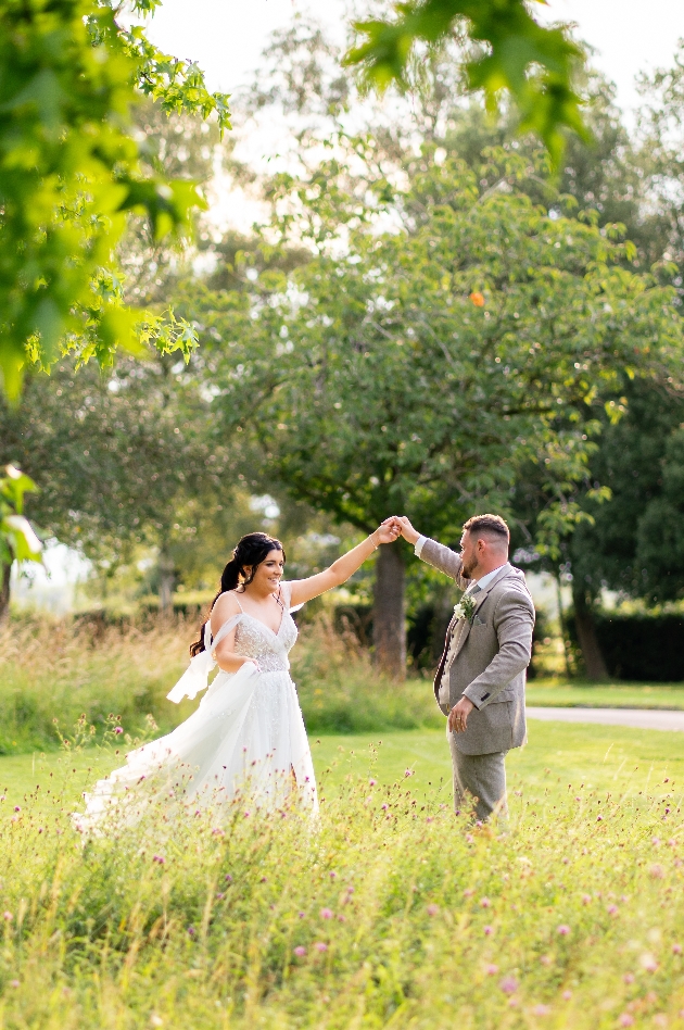 couple dancing on the grass on their wedding day