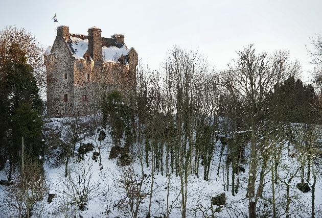 The exterior of Aikwood Tower with the grounds covered in snow