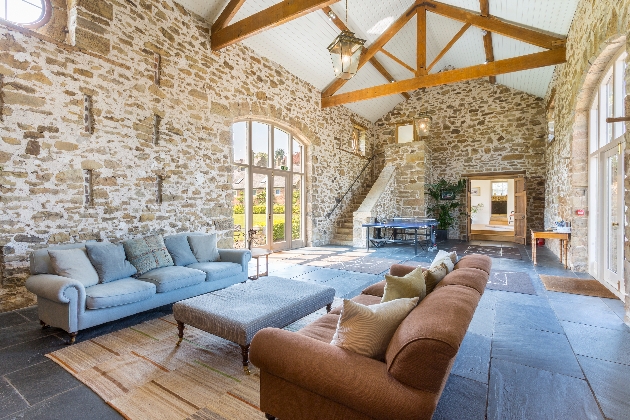 A living room with stone walls and wooden beams on the ceiling